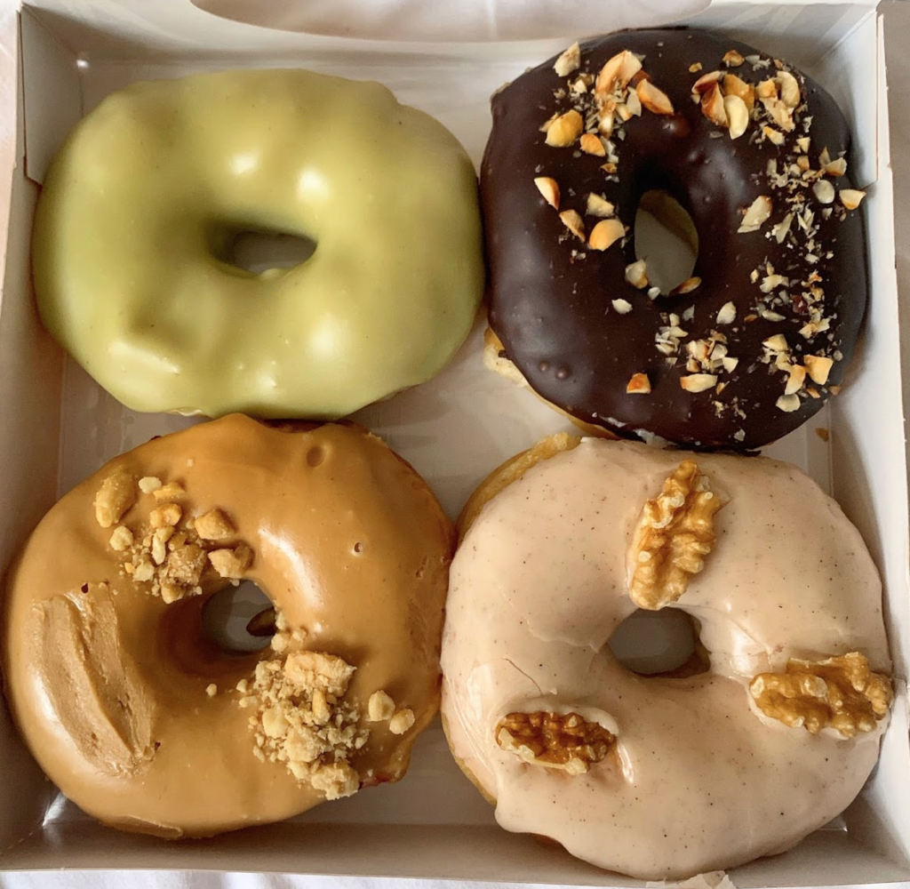 A photo of a box of 4 doughnuts from Blue Vegan Pig Shop, one of the best vegan restaurants in Prague. 